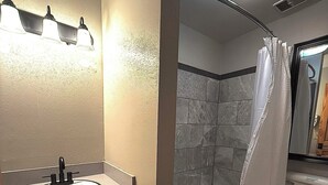 Une salle de bain équipée d’un lavabo, de toilettes, d’une baignoire et d’un rideau de douche.