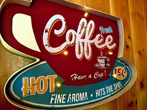 Un letrero antiguo de cafetería con las palabras 'Café', 'Recién hecho', 'CALIENTE', 'Toma una taza' y '15¢'.