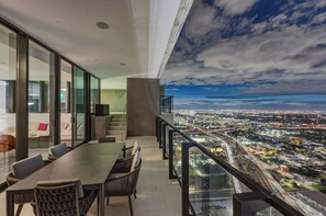 A modern hotel room with a balcony, a dining area, and a city view. - Presidential Penthouse Private Infinity Pool (Miami)