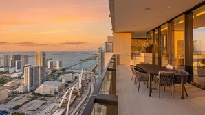 A balcony with a city view, a dining table, and chairs. - Presidential Penthouse Private Infinity Pool (Miami)