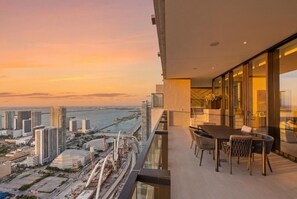 A balcony with a city view, a dining table, and chairs. - Presidential Penthouse Private Infinity Pool (Miami)