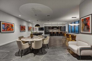 A modern dining area with a round table, chairs, and artwork on the walls. - Presidential Penthouse Private Infinity Pool (Miami)