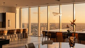 Un comedor moderno con vistas a la ciudad, amplias ventanas y mobiliario contemporáneo.