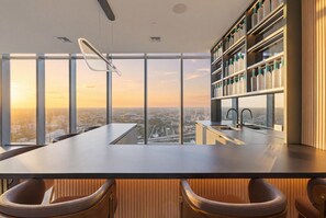 Eine moderne Küche mit einer großen Kochinsel, Barhocker und Blick auf die Stadt.