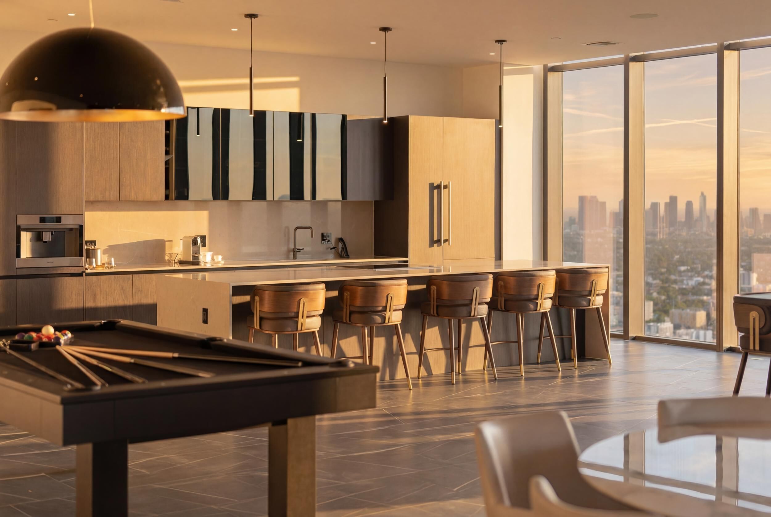 Una cucina moderna con tavolo da biliardo, sgabelli da bar e vista sulla città.