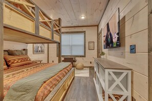 Ein gemütliches Zimmer mit einem Etagenbett, einem Schreibtisch und einem Fernseher.