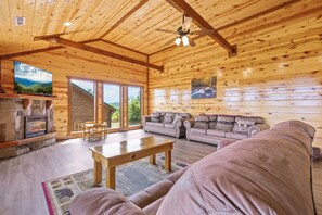 Ein Blockhaus-Interieur mit Kamin, Sofa und Essbereich.