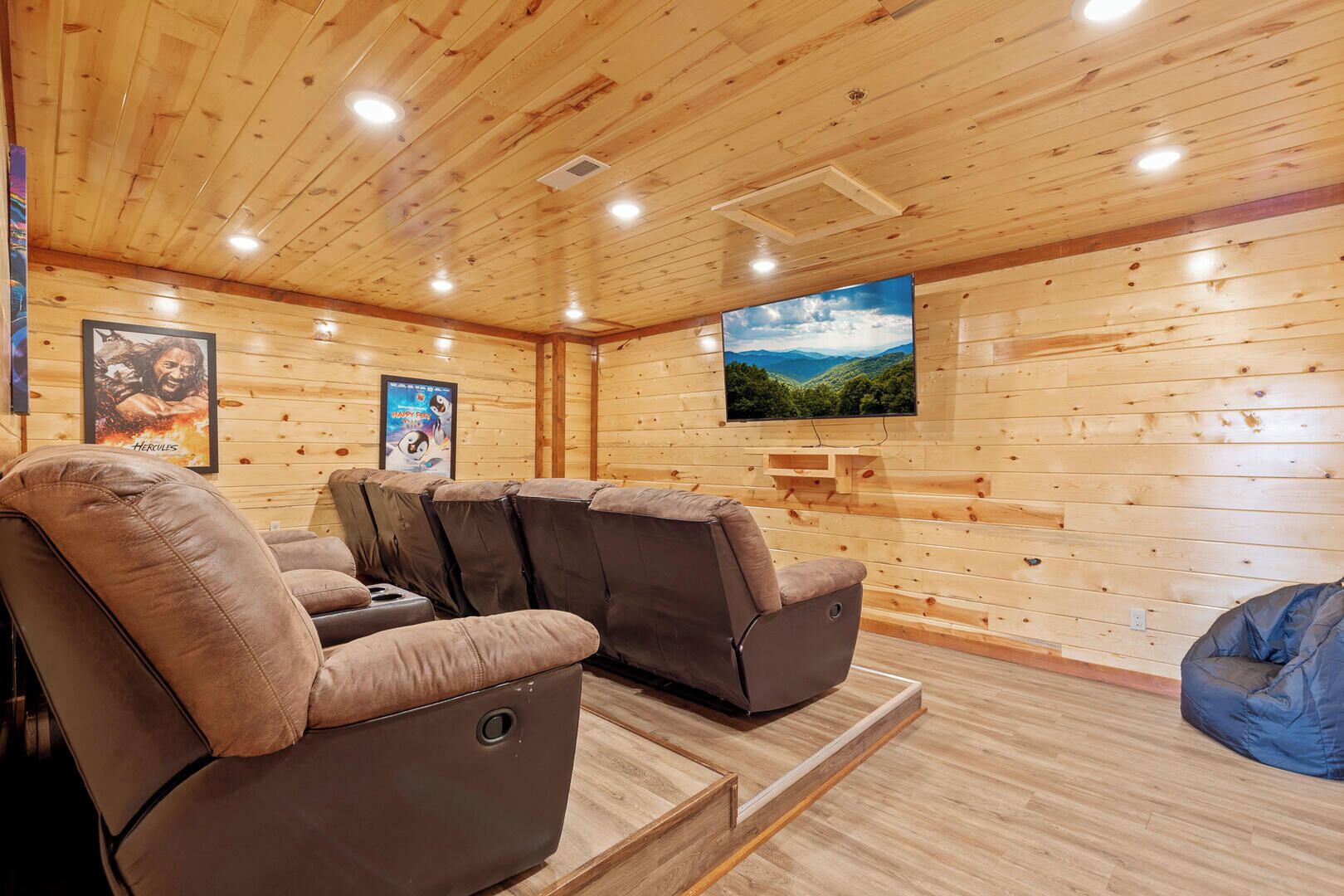 Una habitación con paredes y techo de madera, un televisor de pantalla plana montado en la pared y un sillón reclinable.