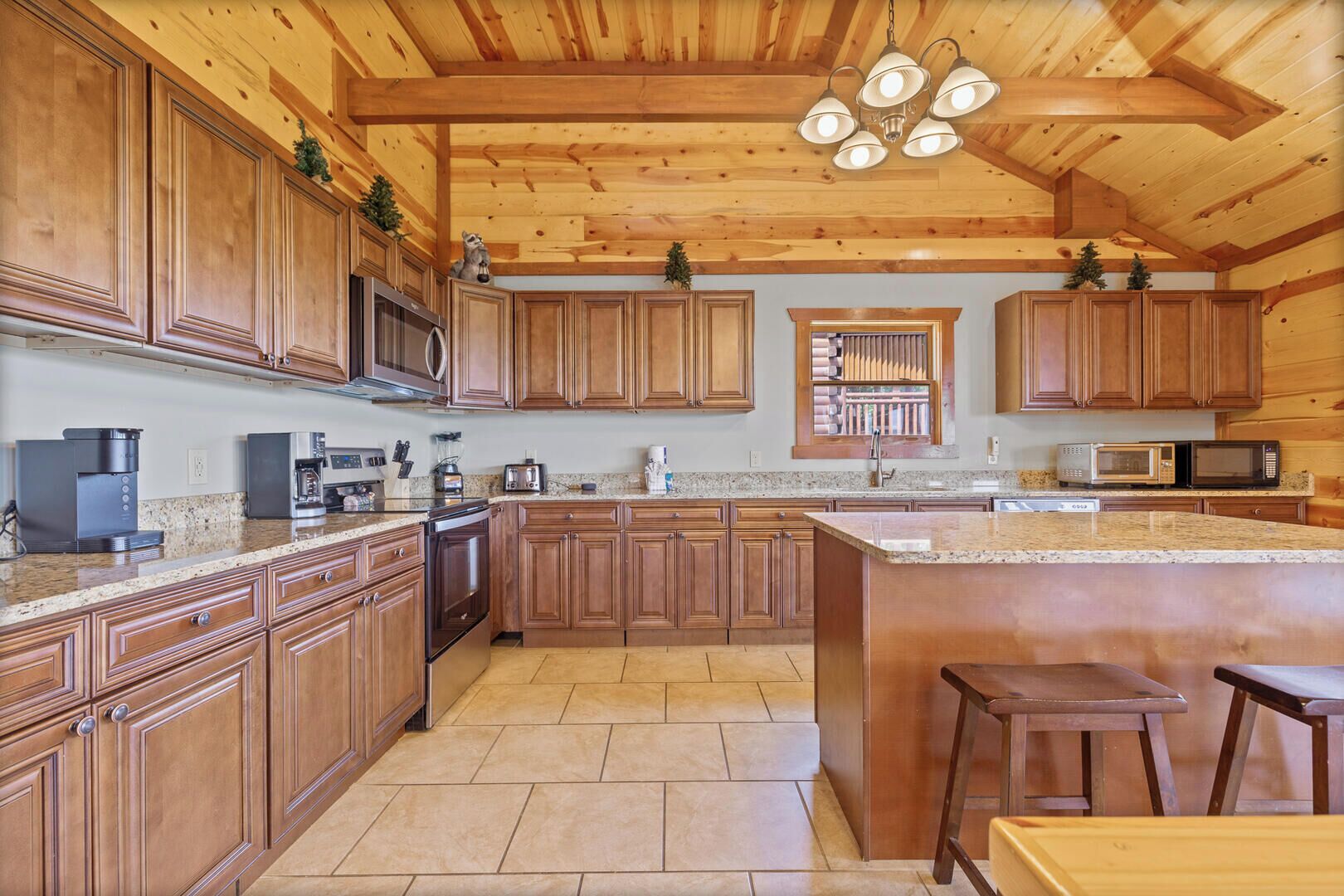 Una cocina con armarios de madera, encimeras de granito, una isla grande y un colgante.