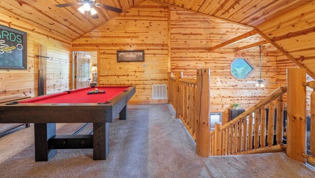A wooden interior with a pool table, ceiling fans, and a staircase. - Welcome to This4br/4ba Where Modern Luxury and Memories Come Together! (Sevierville)