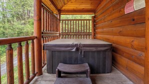 A wooden cabin with a hot tub, wooden deck, and a bench. - Welcome to This4br/4ba Where Modern Luxury and Memories Come Together! (Sevierville)