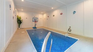 A swimming pool with a basketball hoop, a potted plant, and decorative wall art. - Welcome to This4br/4ba Where Modern Luxury and Memories Come Together! (Sevierville)