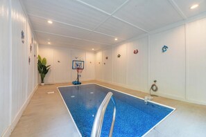 A swimming pool with a basketball hoop, a potted plant, and decorative wall art. - Welcome to This4br/4ba Where Modern Luxury and Memories Come Together! (Sevierville)
