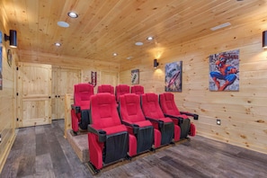 Ein Holzinnenraum mit einer Reihe roter Stühle, Holzwänden und Deckenleuchten.