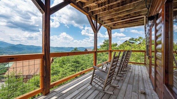 Un pontile in legno con vista su montagne e vegetazione.