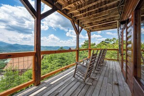 Une terrasse en bois offrant une vue sur les montagnes et la verdure.
