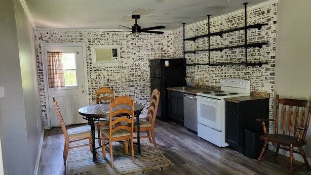 A kitchen with a dining table, chairs, a refrigerator, stove, and a ceiling fan.
