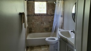 A bathroom with a bathtub, toilet, and sink.