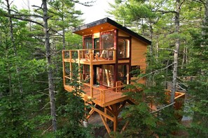 Eine mehrstöckige Holzhütte in einem Wald.