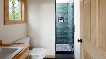 A bathroom with a toilet, sink, and a window.