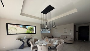 Un comedor moderno con una mesa redonda, sillas e iluminación colgante.