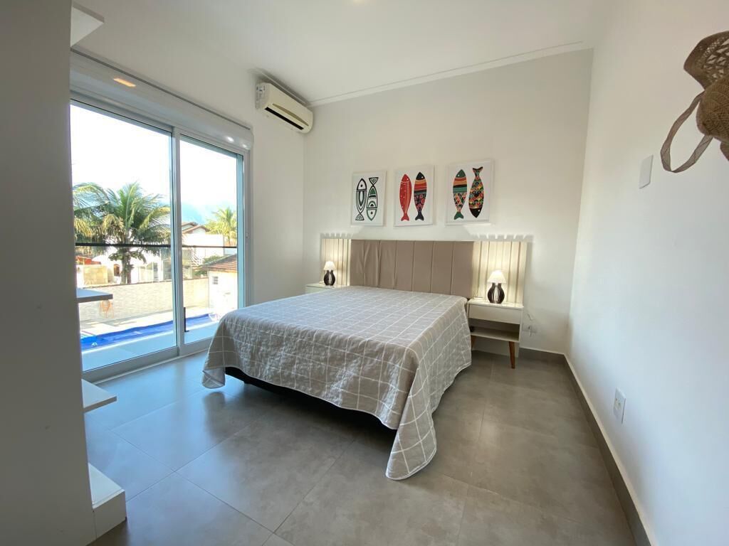 Une chambre à coucher avec un lit, une fenêtre et des œuvres d’art murales.