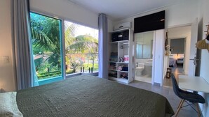 Un dormitorio con una cama grande, un escritorio, una silla, un armario y un baño.