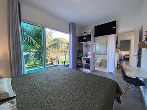 Ein Schlafzimmer mit einem großen Bett, einem Schreibtisch, einem Stuhl, einem Kleiderschrank und einem Badezimmer.