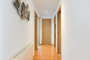 A hallway with wooden doors, a radiator, and decorative wall art.
