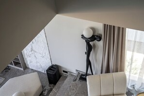 Un salon moderne avec un sol en marbre, un lampadaire et un canapé.