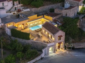A stone building with a swimming pool, outdoor seating, and a staircase leading to the entrance. - Villa Methorion Manor - With Private Pool (Saitoures)