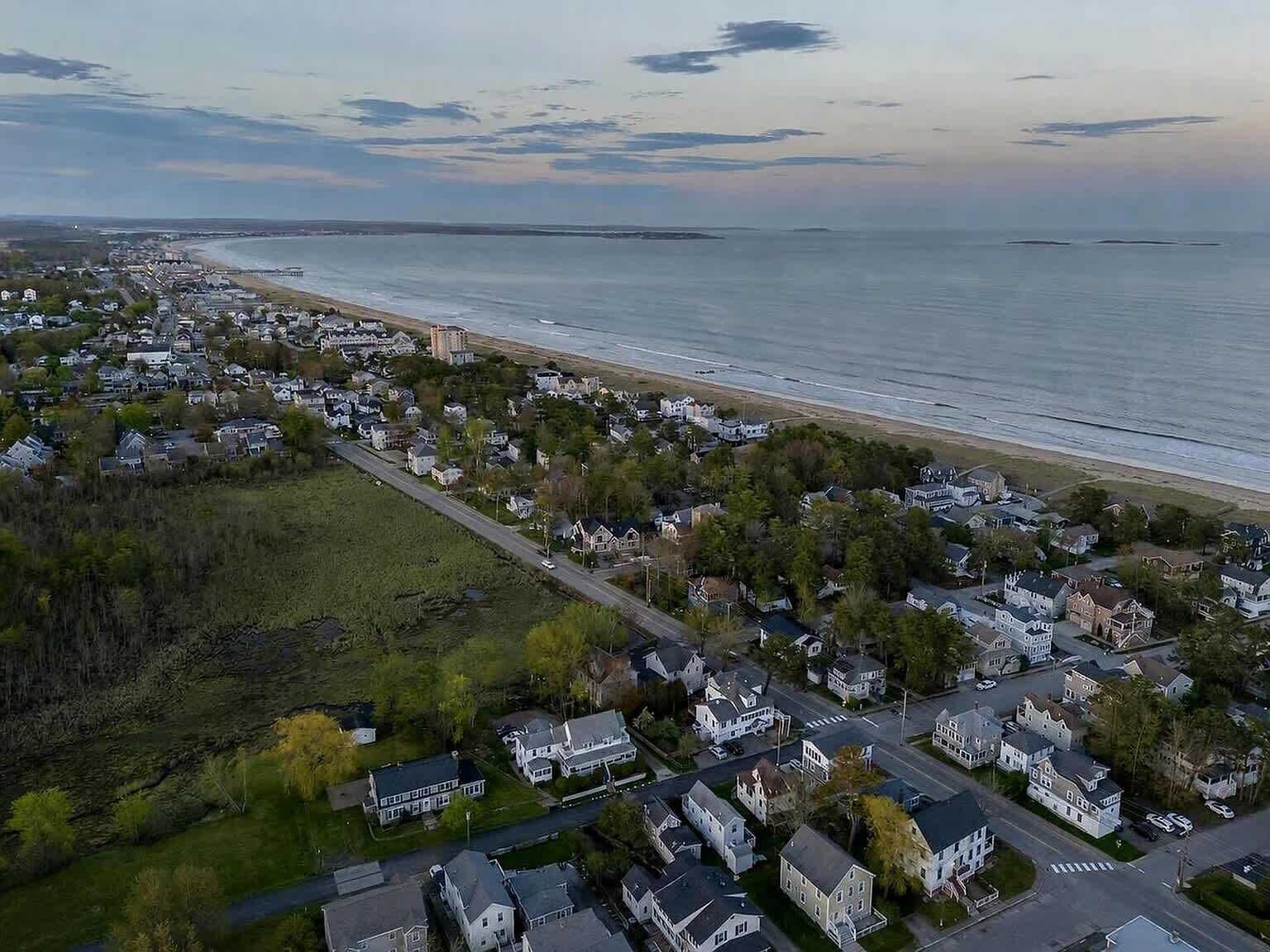 Vista aérea de una zona residencial costera con casas, calles y una playa.