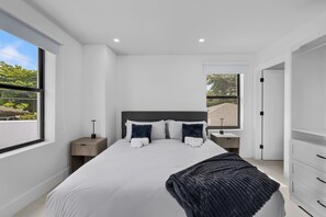 A modern bedroom with a large bed, bedside tables, a wardrobe, and a view of the outdoors. - Luxury Miami Villa w/ Pool, Jacuzzi, BBQ & Pickleball Court (Miami)