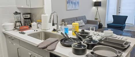 A modern kitchen with a dishwasher, a sink, and various cooking utensils.