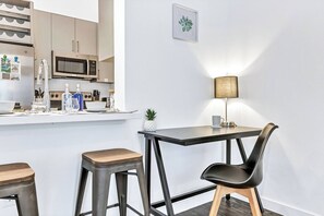 A modern kitchen with a microwave, stove, and bar area with stools. - Quiet Getaway | Weekly & Monthly Discounts (Richardson)