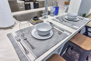 Een moderne keuken met een centraal eiland, roestvrijstalen apparatuur en een bar.