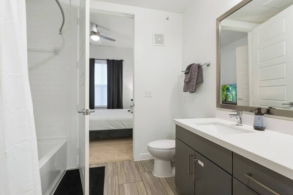 Un baño moderno con ducha, inodoro y lavamanos.