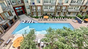 Ein mehrstöckiges Wohngebäude mit Pool auf dem Dach, Balkonen und Außenbereichen zum Sitzen.