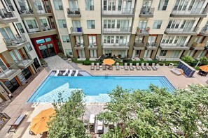 Ein mehrstöckiges Wohngebäude mit Pool auf dem Dach, Balkonen und Außenbereichen zum Sitzen.