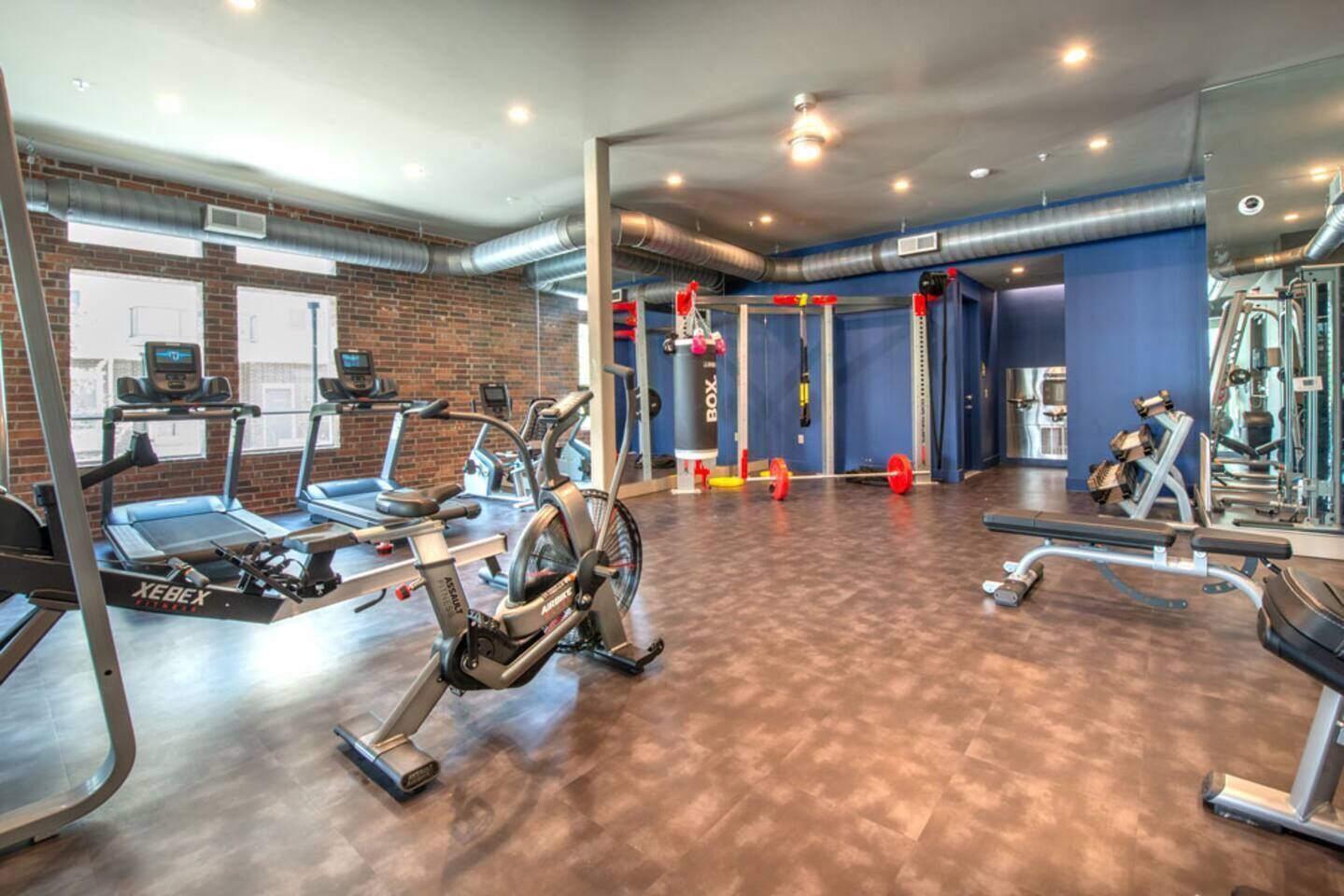 Ein Fitnessraum mit Laufbändern, Crosstrainern und Krafttrainingsgeräten.