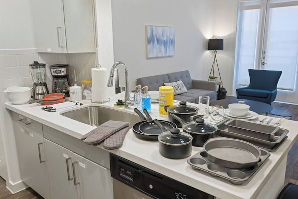 A modern kitchen with a dishwasher, a sink, and various cooking utensils. - Near Trails & Eats | Weekly & Monthly Specials (Richardson)