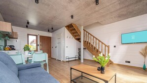 A modern living space with a kitchen, dining area, and staircase. - Pleasant 2-bedroom house with AC in charming Mielenko (Mielenko)