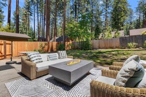 A backyard with a fire pit, outdoor furniture, and tall trees. - Zephyr Cove Gem - 2-min walk to HOA Beach! (Zephyr Cove)