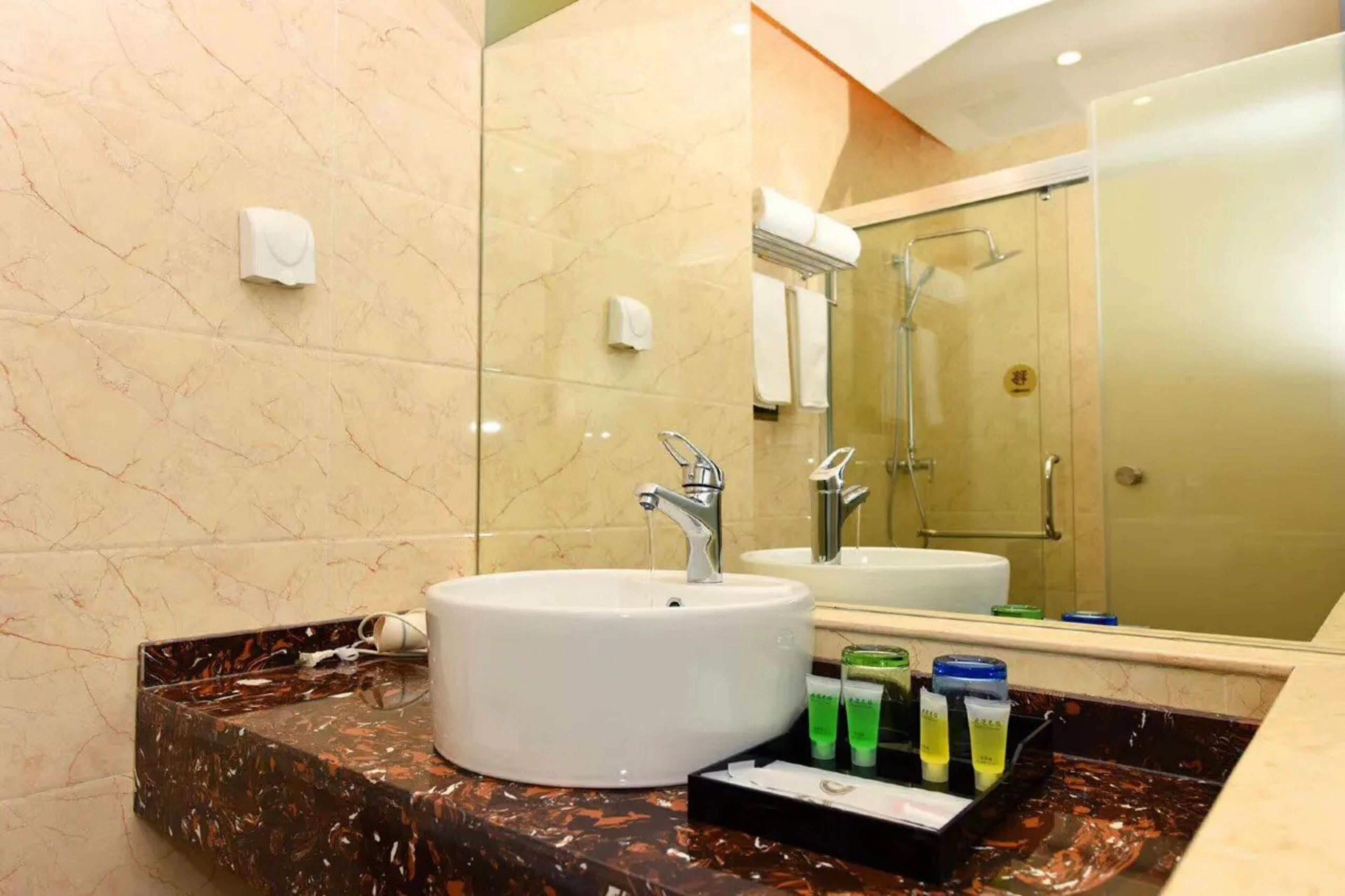 A bathroom with a white sink, a mirror, and a glass shower enclosure.