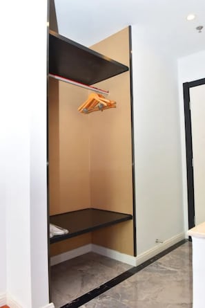Una habitación con armario empotrado, una pequeña estantería y suelo de mármol.