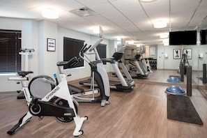 A gym with stationary bikes, treadmills, and exercise equipment.