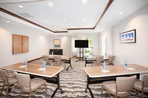 A conference room with two tables, chairs, a flat-screen TV, and a large window. - King Suite Near Denver Airport | Free Breakfast (Denver)