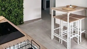 A modern kitchen with a neon sign, a dining area with stools, and a wall-mounted neon sign.