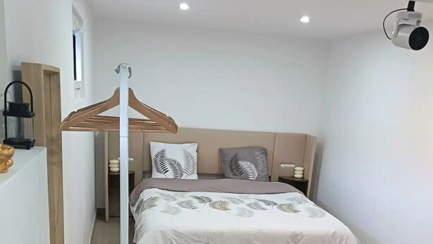 A modern bedroom with a bed, bedside tables, a desk, and a chair.