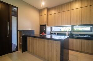Een moderne keuken met houten kastjes, een granieten aanrechtblad en een inbouwoven.